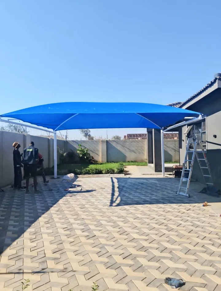 Blue cantilever shade over a paved courtyard
