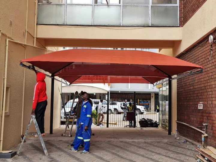 Double cantilever shade over a business entrance and walkway