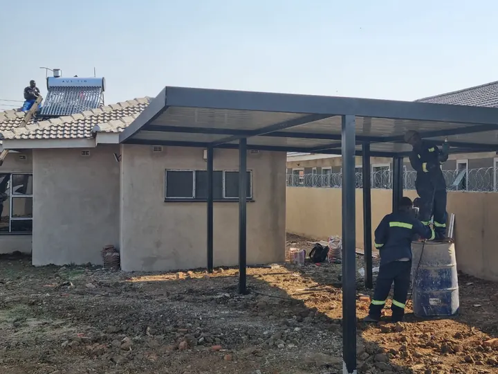 Our team fixing roof sheets onto a steel frame